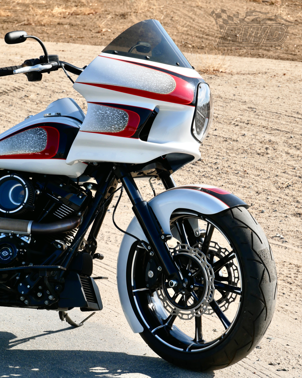 A white and red Harley Davidson motorcycle parked on pavement with RWD V-Twin fender installed