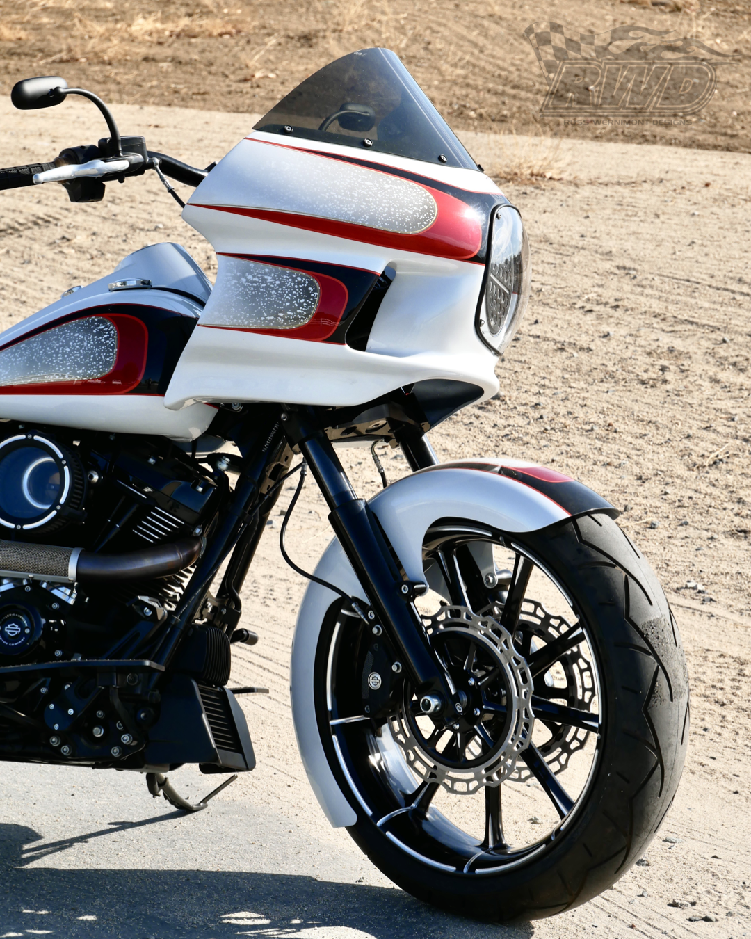A white and red Harley Davidson motorcycle parked on pavement with RWD V-Twin fender installed