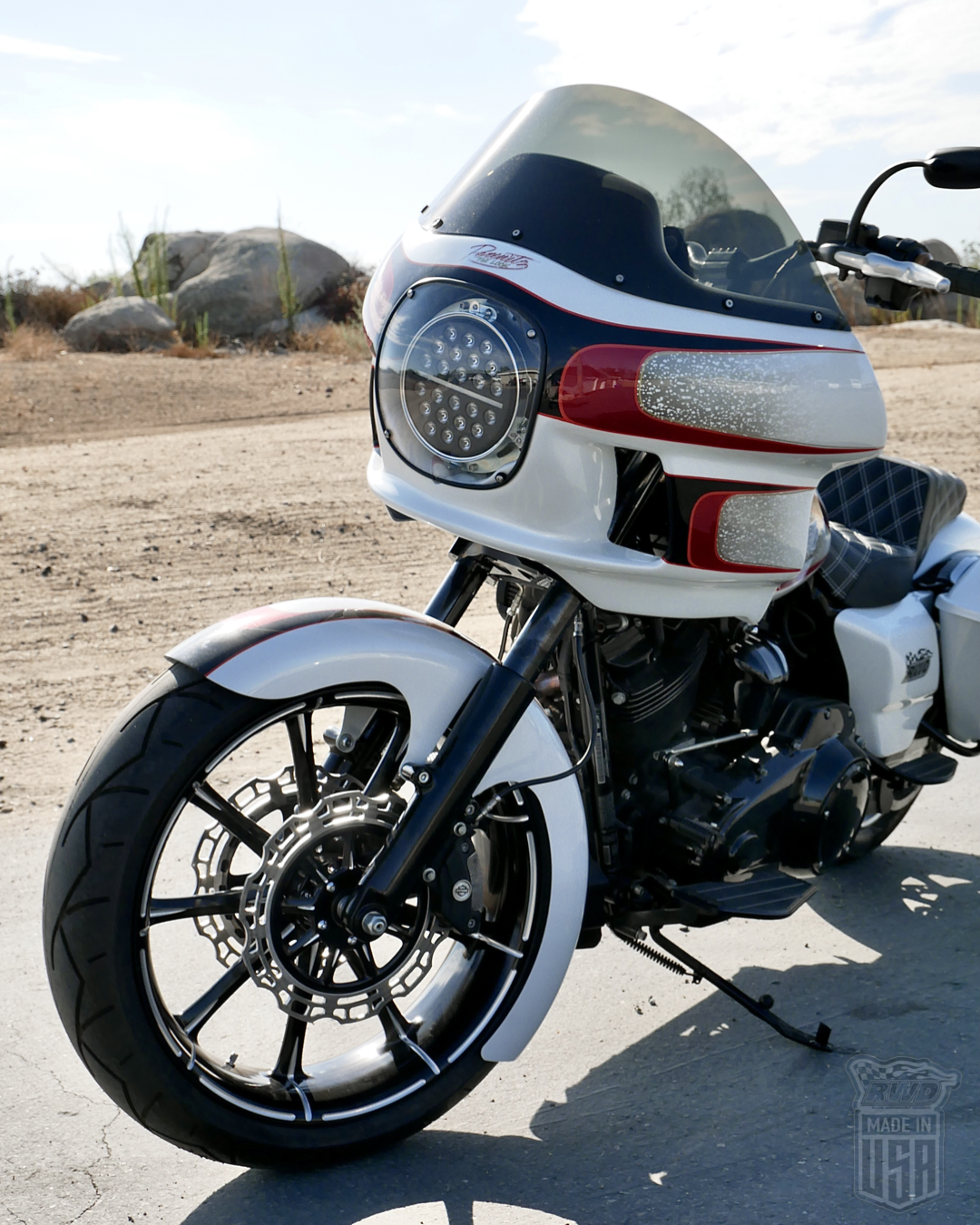 A white and red Harley parked on pavement with RWD V-Twin fender installed