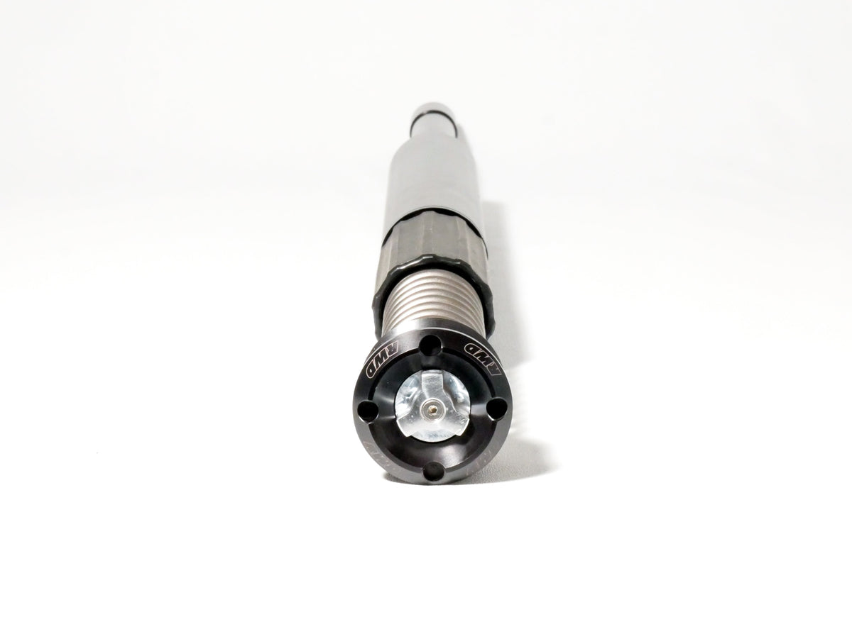 A close-up, eye-level shot of an RWD V-Twin RS-1F front fork cartridge, showcasing its black anodized cap with the RWD logo, silver spring, and gray body against a clean white background.